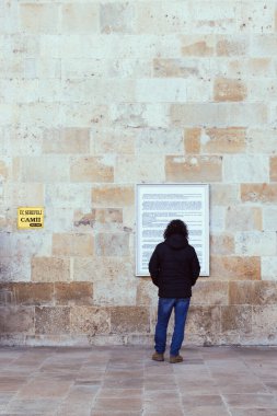 Bir adam Edirne 'deki UC camisinin tarihi açıklamasını okuyor. 