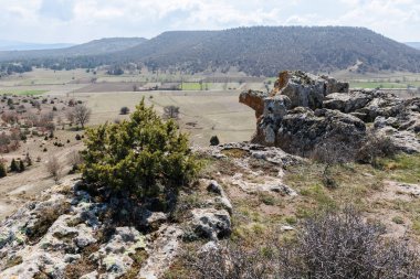 Bulutlu gökyüzünün altındaki vadideki Frig Vadisi 'ndeki antik kayalar ve tarlalar