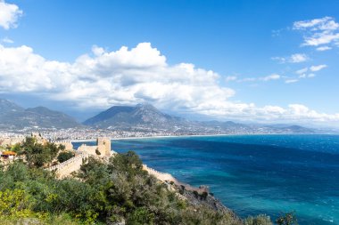 Güneşli bir günde Alanya şehri ve dağların üzerindeki bulutlar
