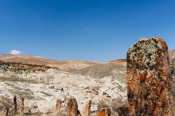 Mavi gökyüzü ve Konya 'daki dağ manzarasının altındaki mezarlıkta antik taş mezar taşları