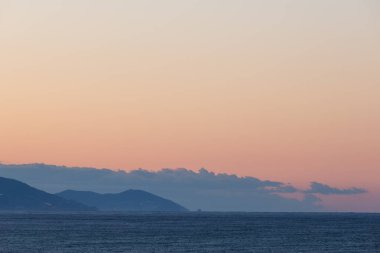 Akdeniz kıyılarında gün doğumu Alanya 'dan ve uzak mesafeden deniz üzerinde bulutlar