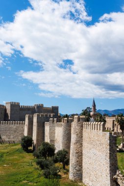 Mersin, Türkiye 'deki antik Mamure Şatosu' nun duvarları ve bulutlu mavi gökyüzü minare karınca