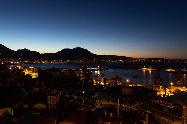 Городское освещение и порт Алании на рассвете в Анталии, недалеко от Средиземного моря, Турция