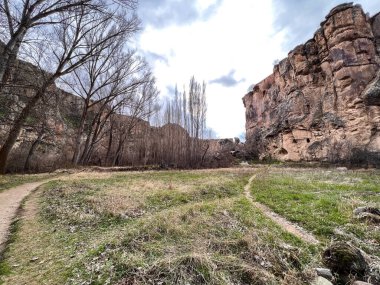 Büyük kıvrımlı bir patika ve vadide küçük kıvrımlı bir yol.