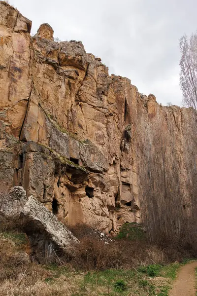 Dağlardaki eğimli taş mağaralar, toprak patika yakınlarında.