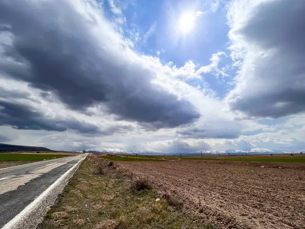 Kırsal kesimdeki bir çiftlik arazisinin yakınında boş bir asfalt yol.