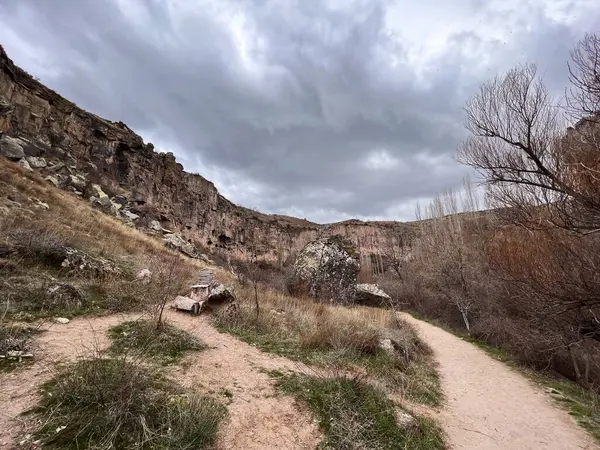 Bulutlu bir günde dağdaki küçük mağaralara giden kirli bir yol.