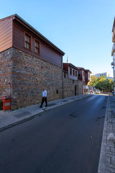 İstanbul, uskudar 'da restore edilmiş antik manastır ve sokak manzarasının önünden geçen bir adam.