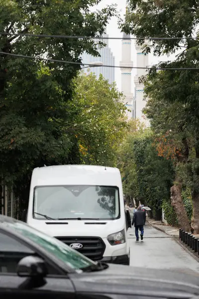 people walking on the street and Levent Hayreddin Barbaros Pasa mosque's minarets at distance in istanbul