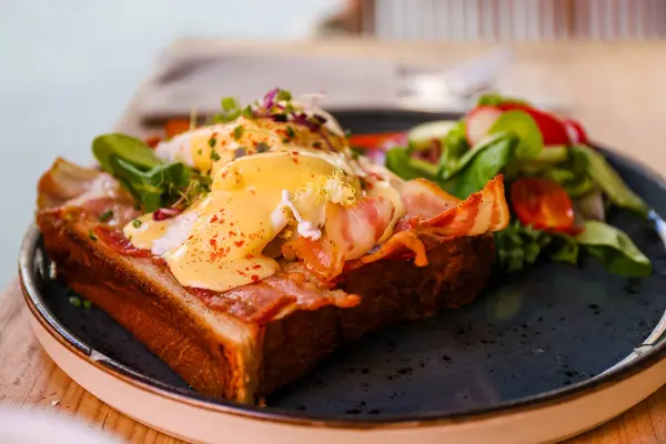 Yumurtalı kızarmış ekmek, pastırma ve holandez sosu.