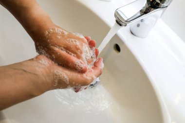 Banyo lavabosunda sabunla ellerini yıkamak, hijyen kavramı.