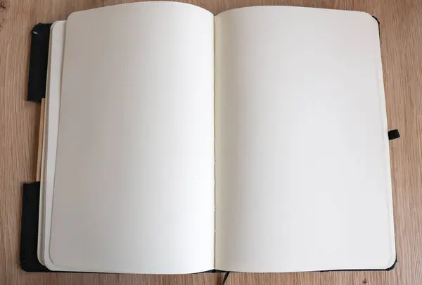 Ahşap masa arkasında boş bir defter. Boş sayfalar. Üst görünüm