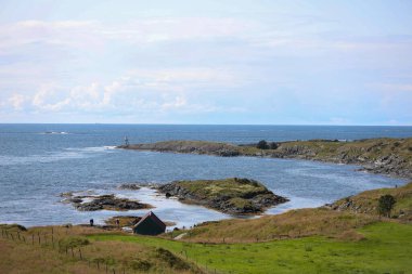 Norveç 'te küçük bir deniz feneri ile Haugesund kıyılarının panoramik manzarası.