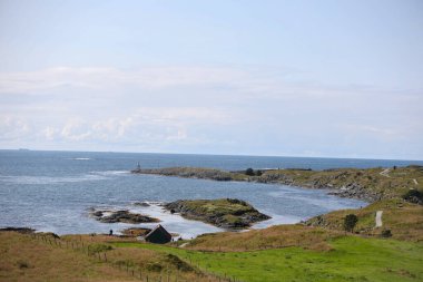 Norveç 'te küçük bir deniz feneri ile Haugesund kıyılarının panoramik manzarası.