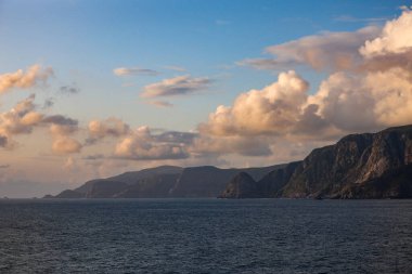 Gün batımında bulutları ve dağları olan güzel deniz manzarası. Güzel doğal arkaplan.