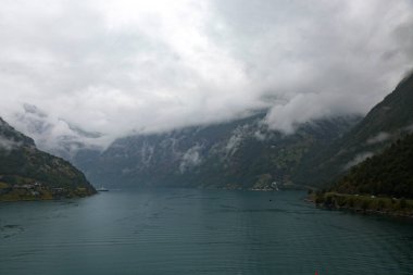 Norveç 'teki fiyort ve dağların manzarası Yağmurlu, bulutlu ve sisli bir günde.