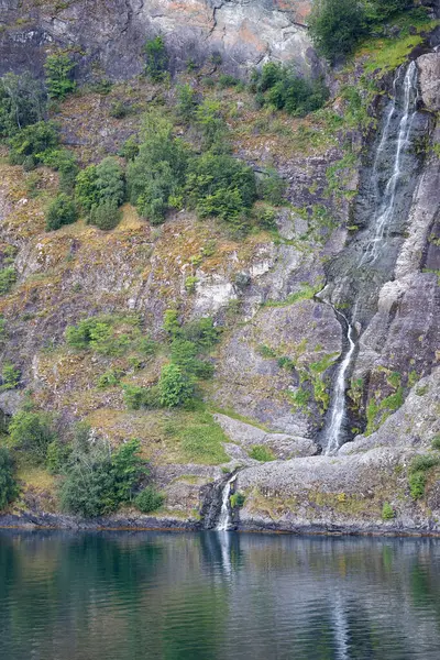 Waterfall in the fjord in Norway. Summer landscape.