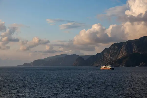 Norveç ve İskandinavya 'daki dağların ve bulutların arka planında, denizde bir gemi gezisi.