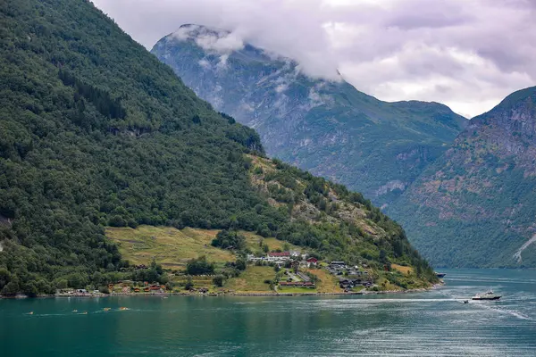 Geiranger, bulutlu evler ve dağlarla dolu bir arazi..