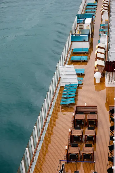 Yağmurdan sonra masaları ve sandalyeleri olan bir yolcu gemisinin güvertesi..