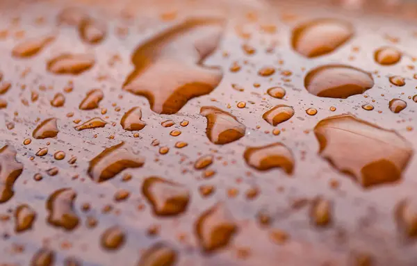 Su, ahşap bir yüzeye düşer. Yakın plan, seçici odaklanma. Makro