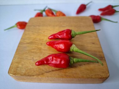 Servis masasında kırmızı biber. Acı bir tadı olan ve sıklıkla yemek ve tıpta kullanılan bir biber türüdür. Bu kırmızı biber ince şekli, parlak kırmızı rengi ve yüksek seviye...