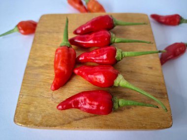 Servis masasında kırmızı biber. Acı bir tadı olan ve sıklıkla yemek ve tıpta kullanılan bir biber türüdür. Bu kırmızı biber ince şekli, parlak kırmızı rengi ve yüksek seviye...