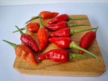 Servis masasında kırmızı biber. Acı bir tadı olan ve sıklıkla yemek ve tıpta kullanılan bir biber türüdür. Bu kırmızı biber ince şekli, parlak kırmızı rengi ve yüksek seviye...