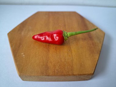 Servis masasında kırmızı biber. Acı bir tadı olan ve sıklıkla yemek ve tıpta kullanılan bir biber türüdür. Bu kırmızı biber ince şekli, parlak kırmızı rengi ve yüksek seviye...