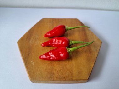 Servis masasında kırmızı biber. Acı bir tadı olan ve sıklıkla yemek ve tıpta kullanılan bir biber türüdür. Bu kırmızı biber ince şekli, parlak kırmızı rengi ve yüksek seviye...