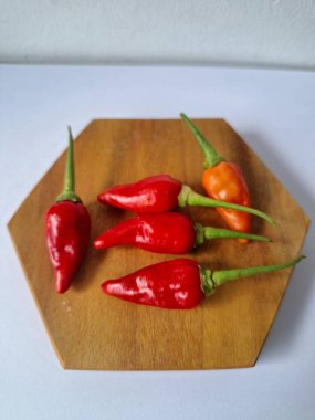 Servis masasında kırmızı biber. Acı bir tadı olan ve sıklıkla yemek ve tıpta kullanılan bir biber türüdür. Bu kırmızı biber ince şekli, parlak kırmızı rengi ve yüksek seviye...