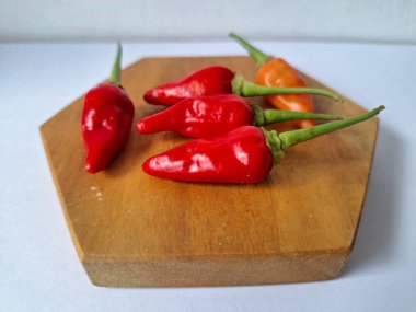 Servis masasında kırmızı biber. Acı bir tadı olan ve sıklıkla yemek ve tıpta kullanılan bir biber türüdür. Bu kırmızı biber ince şekli, parlak kırmızı rengi ve yüksek seviye...