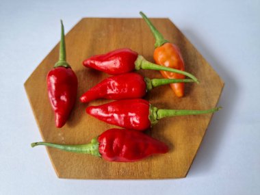 Servis masasında kırmızı biber. Acı bir tadı olan ve sıklıkla yemek ve tıpta kullanılan bir biber türüdür. Bu kırmızı biber ince şekli, parlak kırmızı rengi ve yüksek seviye...