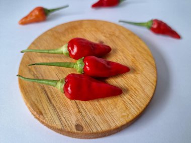 Servis masasında kırmızı biber. Acı bir tadı olan ve sıklıkla yemek ve tıpta kullanılan bir biber türüdür. Bu kırmızı biber ince şekli, parlak kırmızı rengi ve yüksek seviye...