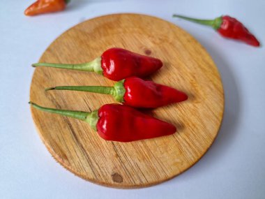 Servis masasında kırmızı biber. Acı bir tadı olan ve sıklıkla yemek ve tıpta kullanılan bir biber türüdür. Bu kırmızı biber ince şekli, parlak kırmızı rengi ve yüksek seviye...