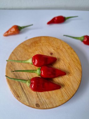 Servis masasında kırmızı biber. Acı bir tadı olan ve sıklıkla yemek ve tıpta kullanılan bir biber türüdür. Bu kırmızı biber ince şekli, parlak kırmızı rengi ve yüksek seviye...