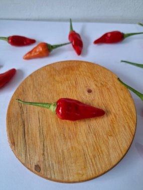 Servis masasında kırmızı biber. Acı bir tadı olan ve sıklıkla yemek ve tıpta kullanılan bir biber türüdür. Bu kırmızı biber ince şekli, parlak kırmızı rengi ve yüksek seviye...