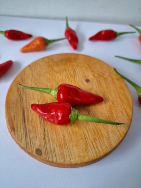 Servis masasında kırmızı biber. Acı bir tadı olan ve sıklıkla yemek ve tıpta kullanılan bir biber türüdür. Bu kırmızı biber ince şekli, parlak kırmızı rengi ve yüksek seviye...