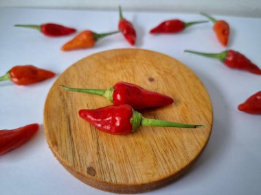 Servis masasında kırmızı biber. Acı bir tadı olan ve sıklıkla yemek ve tıpta kullanılan bir biber türüdür. Bu kırmızı biber ince şekli, parlak kırmızı rengi ve yüksek seviye...