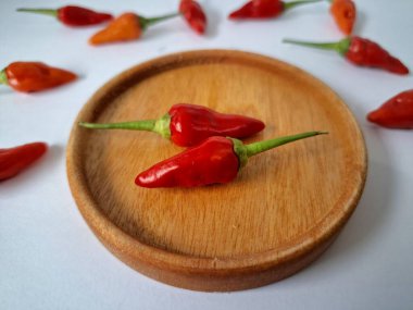 Servis masasında kırmızı biber. Acı bir tadı olan ve sıklıkla yemek ve tıpta kullanılan bir biber türüdür. Bu kırmızı biber ince şekli, parlak kırmızı rengi ve yüksek seviye...