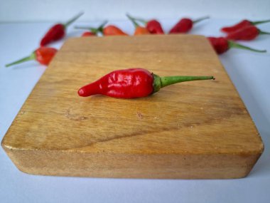 Servis masasında kırmızı biber. Acı bir tadı olan ve sıklıkla yemek ve tıpta kullanılan bir biber türüdür. Bu kırmızı biber ince şekli, parlak kırmızı rengi ve yüksek seviye...