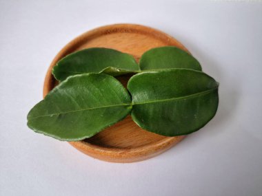 Kafir limon yaprakları. Koyu yeşil, parlak, çift katlı, güçlü, aromalı ve aromalı bir yaprak. Genellikle Güneydoğu Asya mutfağında eşsiz koku ve tatları için kullanılır.