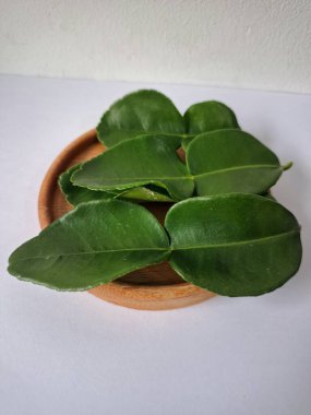 Kafir limon yaprakları. Koyu yeşil, parlak, çift katlı, güçlü, aromalı ve aromalı bir yaprak. Genellikle Güneydoğu Asya mutfağında eşsiz koku ve tatları için kullanılır.