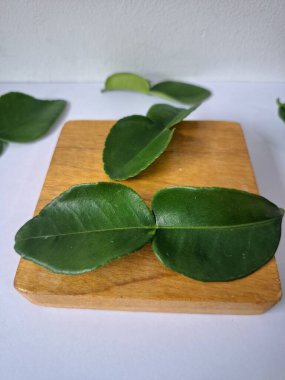 Kafir limon yaprakları. Koyu yeşil, parlak, çift katlı, güçlü, aromalı ve aromalı bir yaprak. Genellikle Güneydoğu Asya mutfağında eşsiz koku ve tatları için kullanılır.