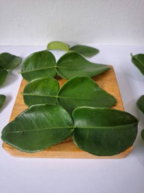 Kafir limon yaprakları. Koyu yeşil, parlak, çift katlı, güçlü, aromalı ve aromalı bir yaprak. Genellikle Güneydoğu Asya mutfağında eşsiz koku ve tatları için kullanılır.