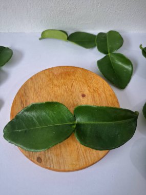 Kafir limon yaprakları. Koyu yeşil, parlak, çift katlı, güçlü, aromalı ve aromalı bir yaprak. Genellikle Güneydoğu Asya mutfağında eşsiz koku ve tatları için kullanılır.