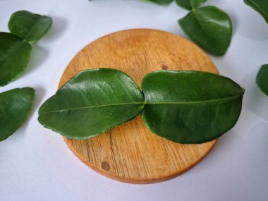 Kafir limon yaprakları. Koyu yeşil, parlak, çift katlı, güçlü, aromalı ve aromalı bir yaprak. Genellikle Güneydoğu Asya mutfağında eşsiz koku ve tatları için kullanılır.