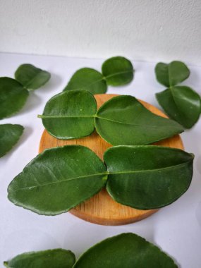 Kafir limon yaprakları. Koyu yeşil, parlak, çift katlı, güçlü, aromalı ve aromalı bir yaprak. Genellikle Güneydoğu Asya mutfağında eşsiz koku ve tatları için kullanılır.