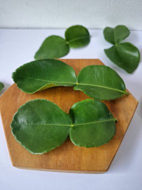 Kafir limon yaprakları. Koyu yeşil, parlak, çift katlı, güçlü, aromalı ve aromalı bir yaprak. Genellikle Güneydoğu Asya mutfağında eşsiz koku ve tatları için kullanılır.