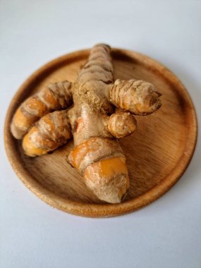 Servis panosundaki taze zerdeçal kökü. Zerdeçal öncelikle Asya mutfağında ve potansiyel sağlık yararları için yemek pişirmede bir baharat olarak kullanılır. Zemin baharatı ve taze kökler gibi çeşitli şekillerde de kullanılır.